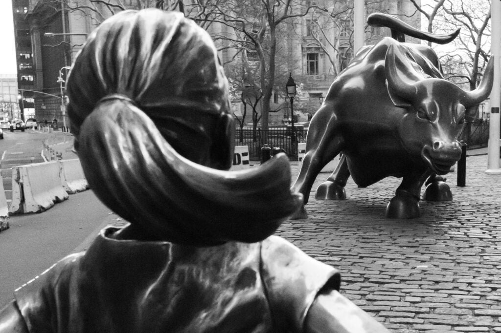 The Fearless Girl bronze statue faces the Charging Bull bronze statue on Wall Street in New York City.
